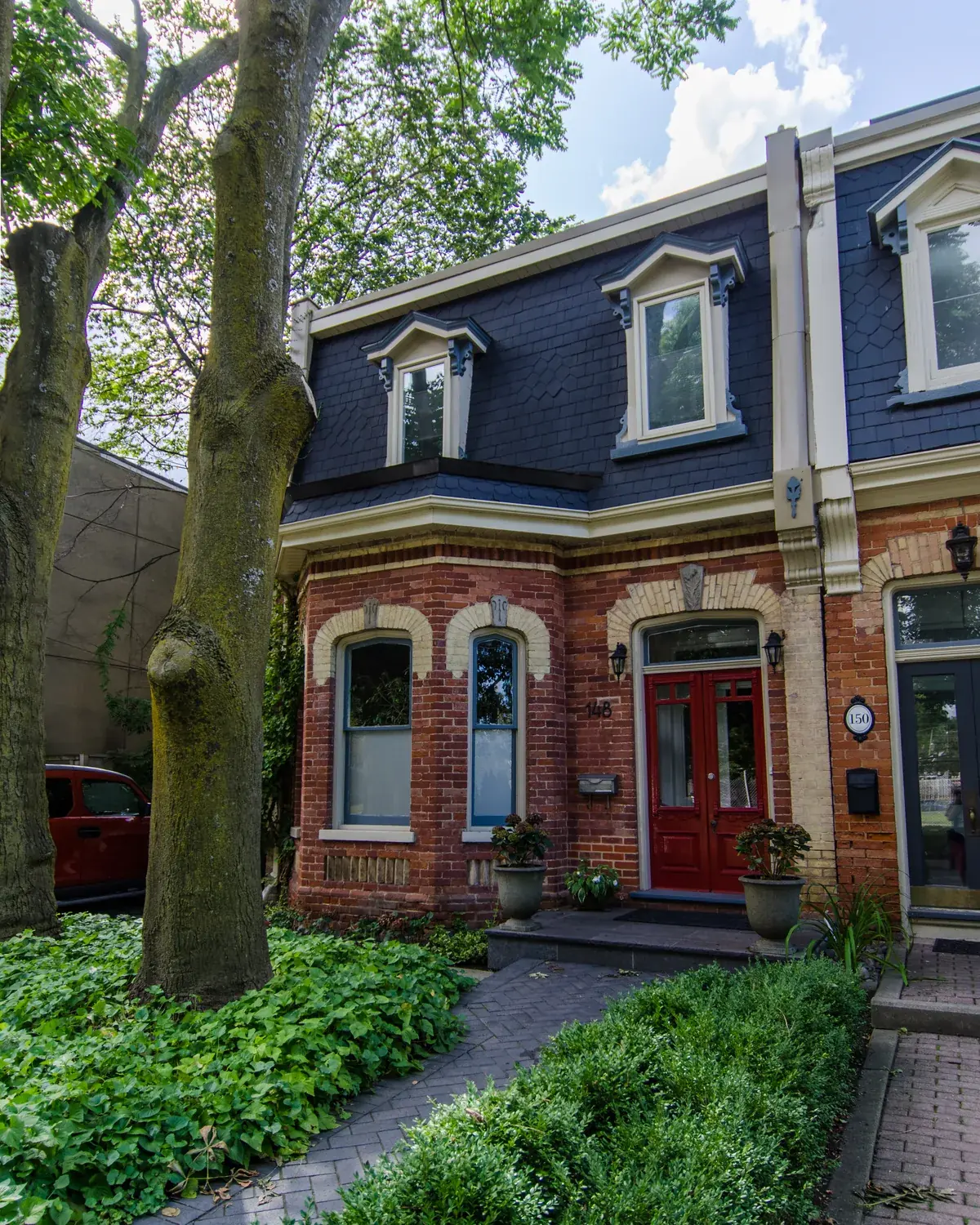 Red double front door of a brick semi-detached house in Toronto
